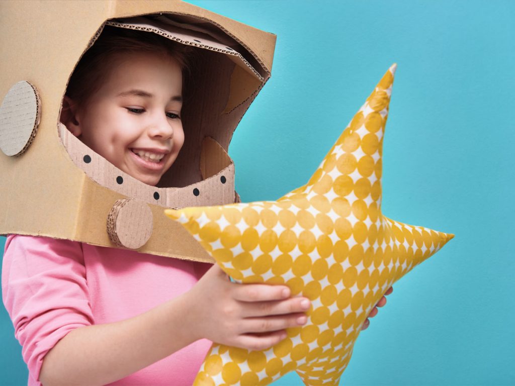 Photo of a girl playing with a star pillow
