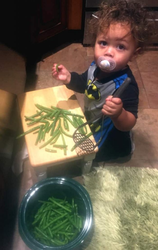 Young child cooking green beans